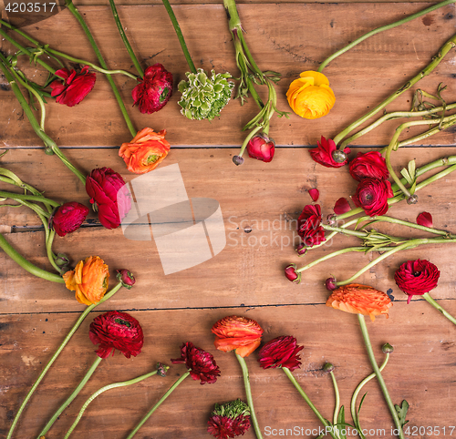 Image of Ranunkulyus bouquet of red flowers on a wooden background