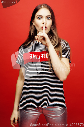 Image of young pretty emitonal posing teenage girl on bright red background, happy smiling lifestyle people concept 