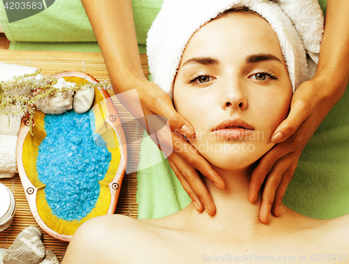 Image of stock photo attractive lady getting spa treatment in salon, close up asian tan hands on face