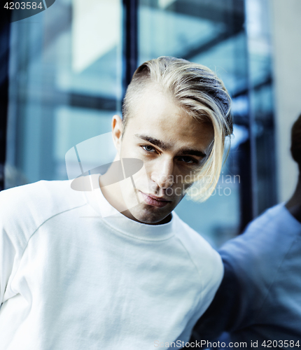 Image of young modern hipster guy at new building university blond fashion hairstyle having fun, lifestyle people concept 