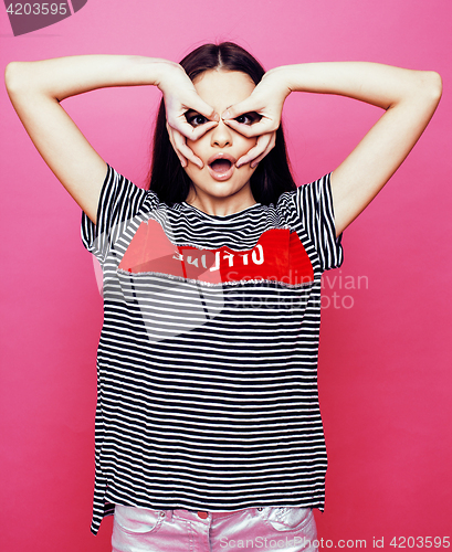 Image of young pretty teenage woman emotional posing on pink background, fashion lifestyle people concept 