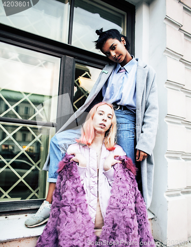 Image of Two teenage girls infront of university building smiling, having