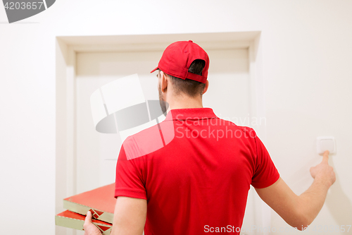 Image of delivery man with pizza boxes ringing doorbell