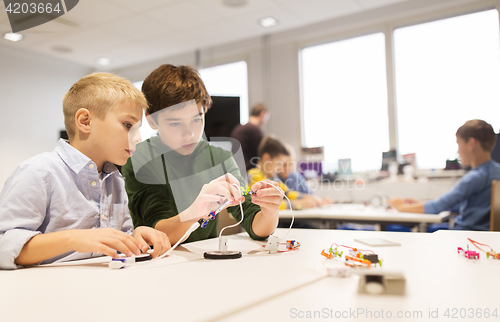 Image of happy children building robots at robotics school