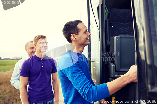 Image of group of happy male passengers boarding travel bus