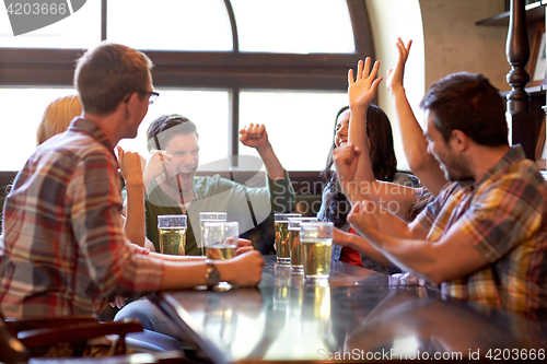 Image of football fans or friends with beer at sport bar