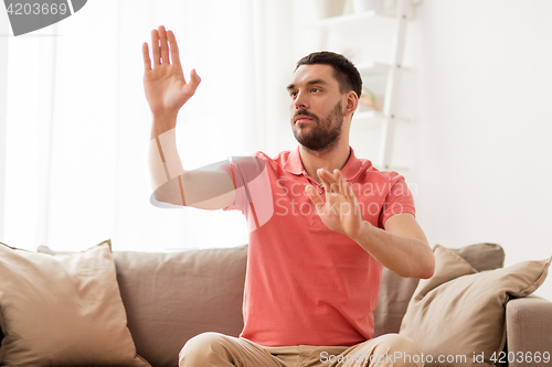 Image of man touching something imaginary at home