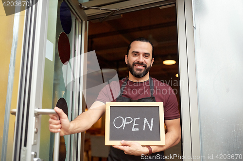 Image of man or waiter with blackboard at bar entrance door