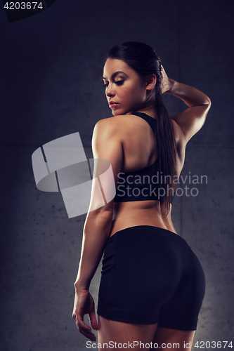 Image of young woman posing and showing buttocks in gym