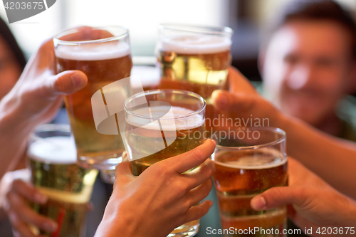 Image of happy friends drinking beer at bar or pub