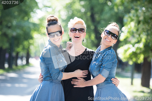 Image of portrait of three young beautiful woman with sunglasses