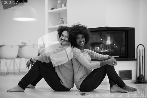 Image of multiethnic couple used tablet computer on the floor