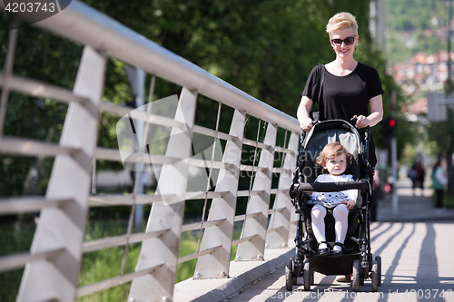 Image of mother pushed her baby daughter in a stroller