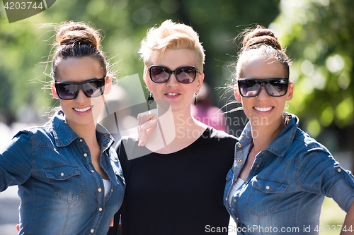 Image of portrait of three young beautiful woman with sunglasses