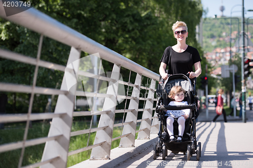 Image of mother pushed her baby daughter in a stroller