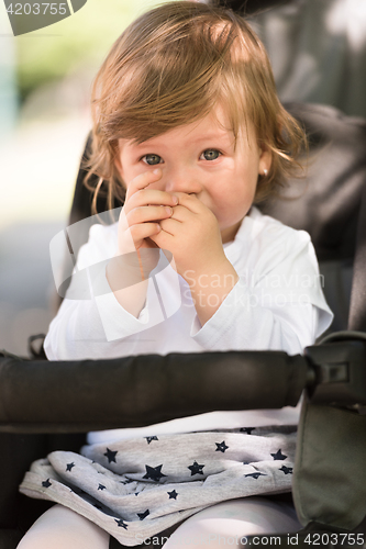 Image of baby girl sitting in the pram