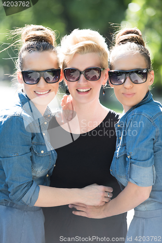 Image of portrait of three young beautiful woman with sunglasses