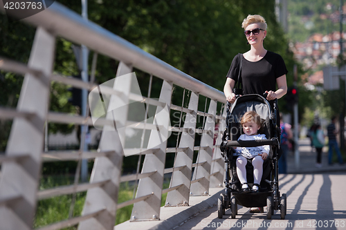 Image of mother pushed her baby daughter in a stroller