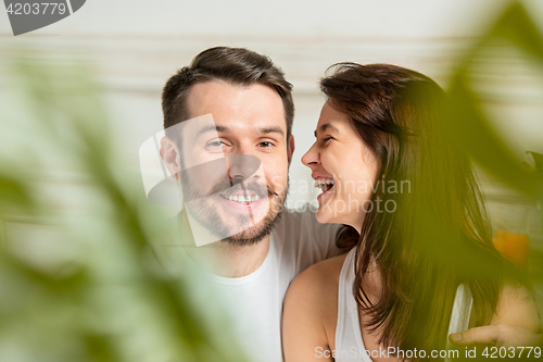 Image of Young adult heterosexual couple lying on bed in bedroom