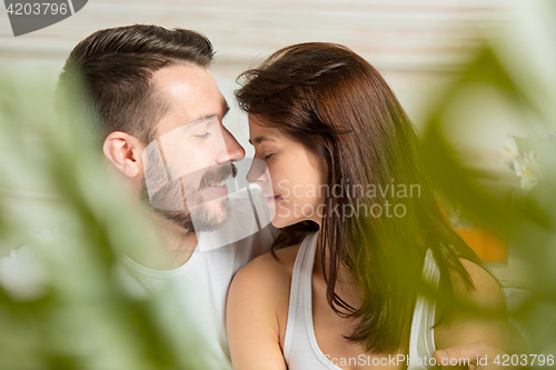 Image of Young adult heterosexual couple lying on bed in bedroom