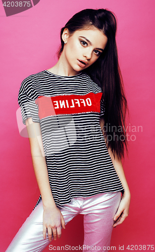Image of young pretty teenage woman emotional posing on pink background, fashion lifestyle people concept 