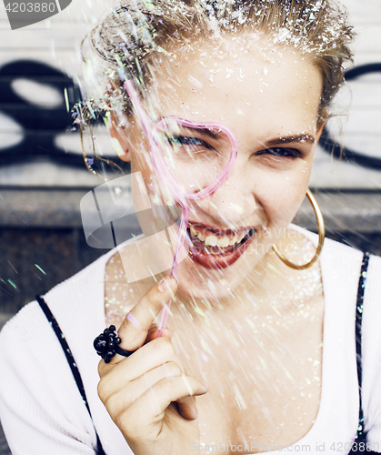 Image of young pretty party girl smiling covered with glitter tinsel, fas