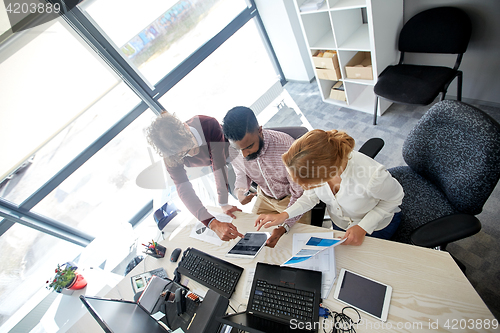 Image of business team with tablet pc and papers at office