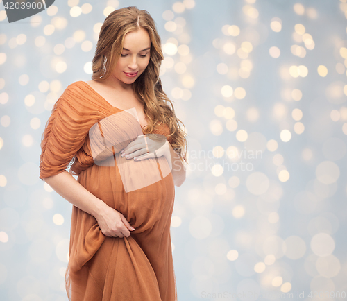 Image of happy pregnant woman touching her big belly