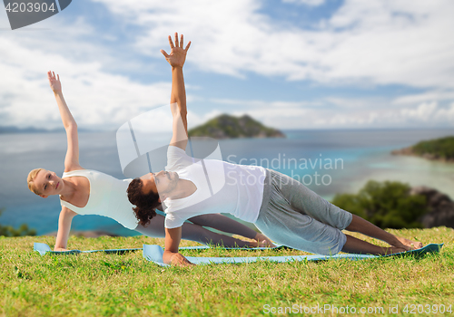 Image of couple doing yoga exercise outdoors