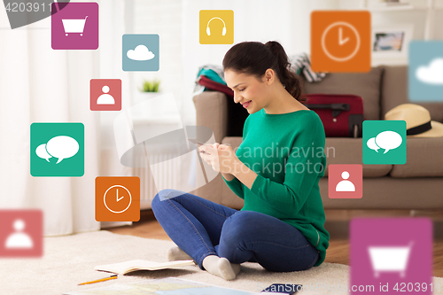 Image of woman with smartphone and travel map at home