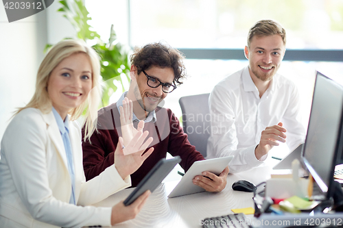 Image of happy business team with tablet pc at office