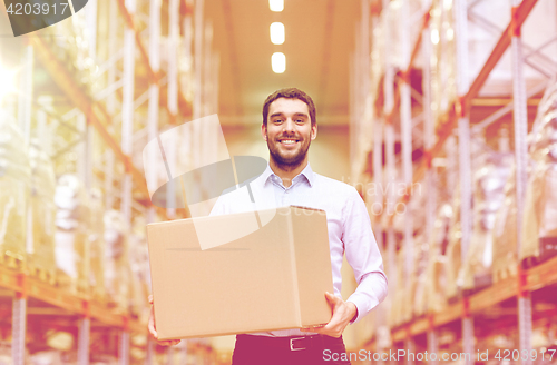 Image of happy man with cardboard parcel box at warehouse