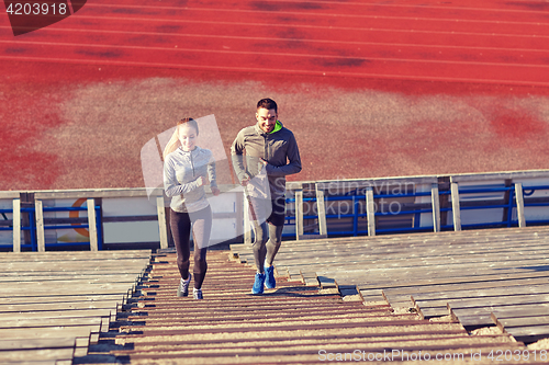 Image of happy couple running upstairs on stadium