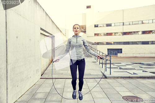 Image of woman exercising with jump-rope outdoors