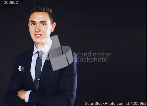 Image of young pretty business man standing on black background, modern h