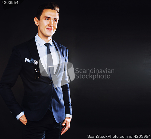 Image of young pretty business man standing on black background, modern h