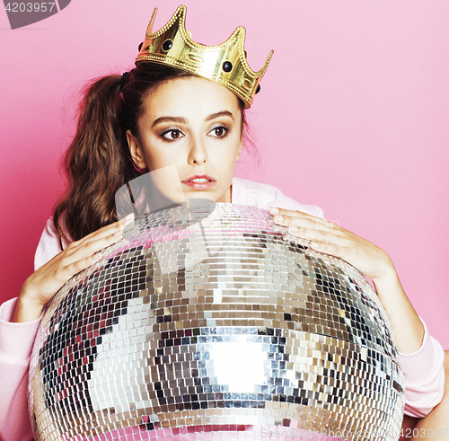 Image of young cute disco girl on pink background with disco ball and cro