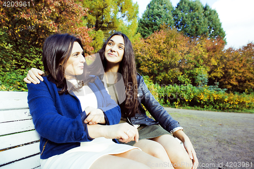 Image of mature real mother with daughter outside autumn fall in park