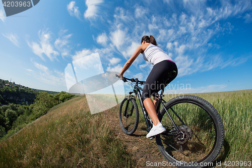 Image of Mountain biking happy sportive girl relax in meadows sunny countryside