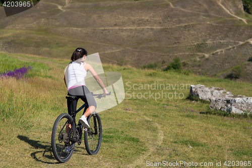 Image of Mountain biking happy sportive girl relax in meadows sunny countryside