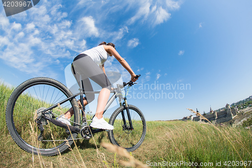 Image of Mountain biking happy sportive girl relax in meadows sunny countryside