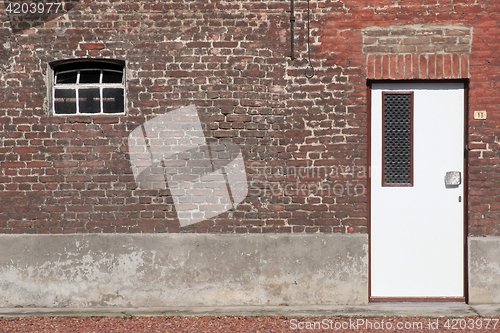 Image of White wooden door in a red brick wall