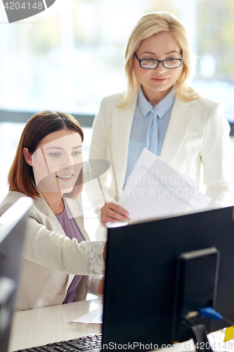 Image of happy business team with computer in office