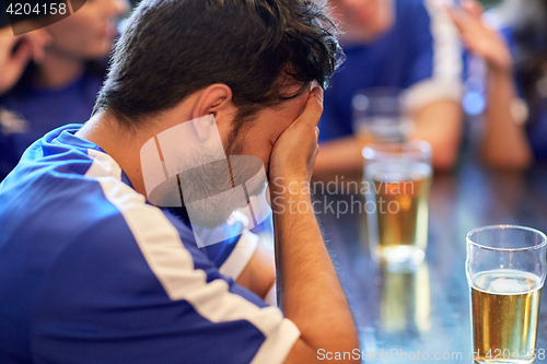 Image of close up of sad football fan at bar or pub