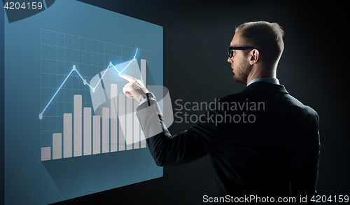 Image of businessman pointing finger to virtual chart