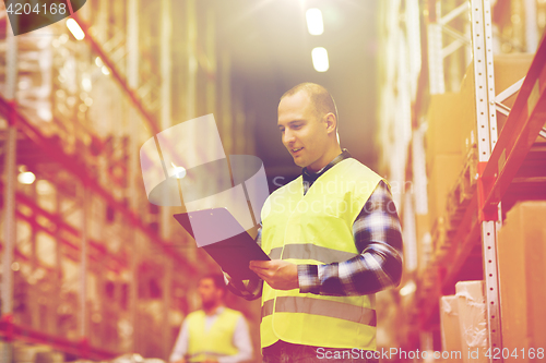 Image of man with clipboard in safety vest at warehouse