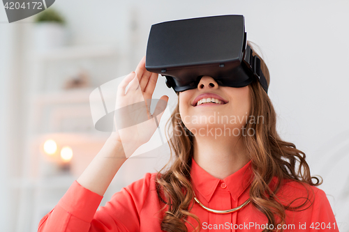 Image of happy woman in virtual reality headset at home