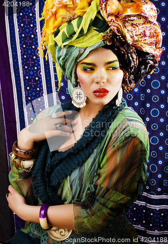 Image of beauty bright woman with creative make up, many shawls on head l