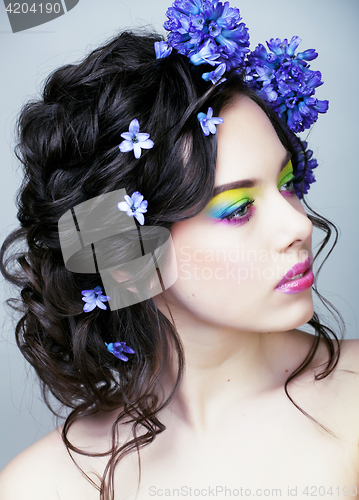 Image of Beauty young woman with flowers and make up close up, real sprin