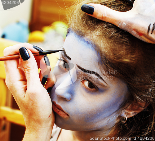 Image of little cute child making facepaint on birthday party, zombie Apo